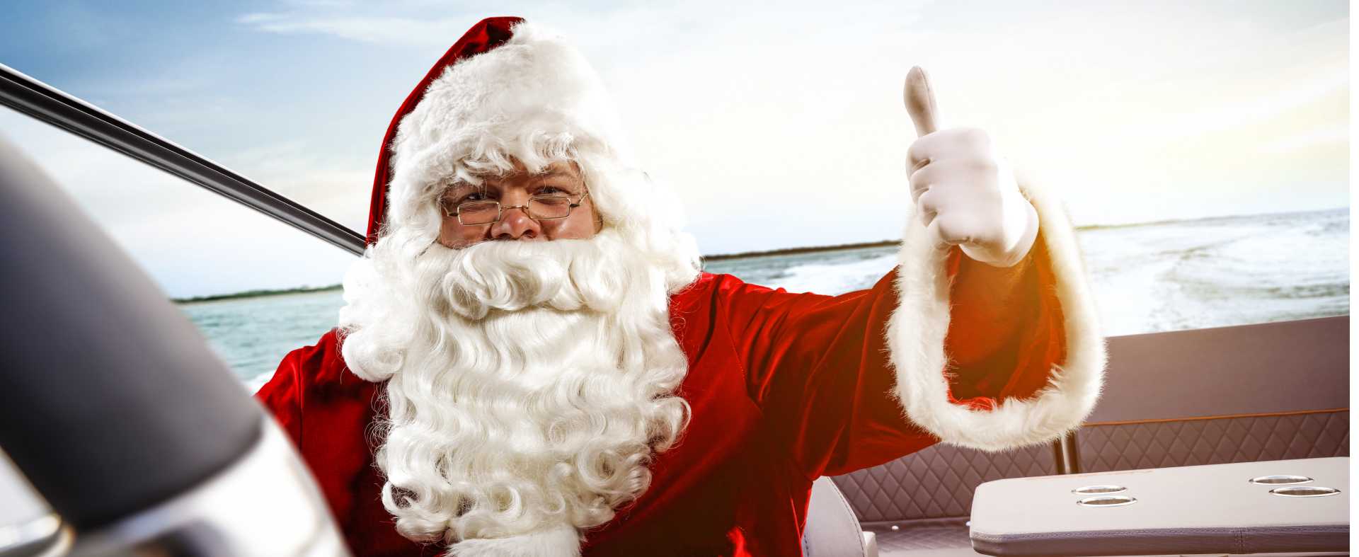 Weihnachtsfeiern und Glühweinfahrten - Weihnachtsmann auf Boot mit Daumen hoch